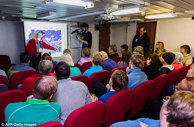 Passengers receiving a briefing about the latest ice conditions report from expedition co-leader Greg Mortimer